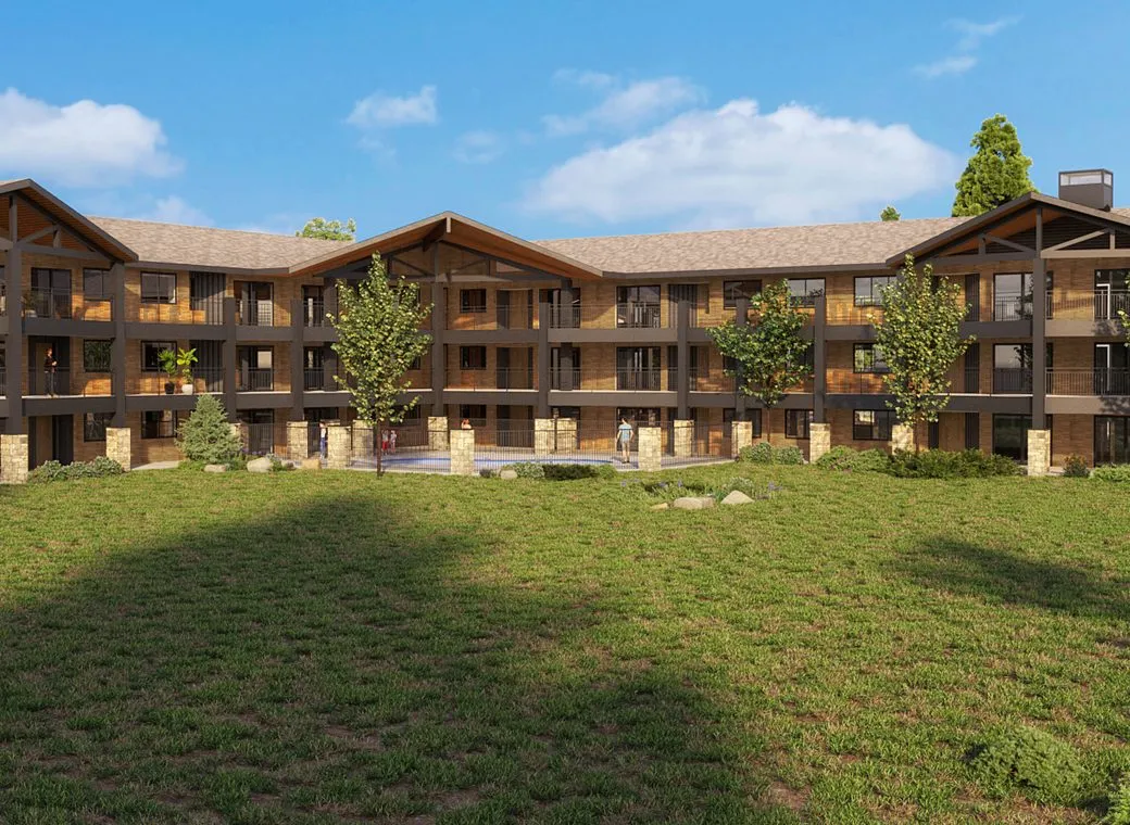 The back elevation in the final scheme: three storeys of timber balconies on stone piers, gabled roofs, lawn in front